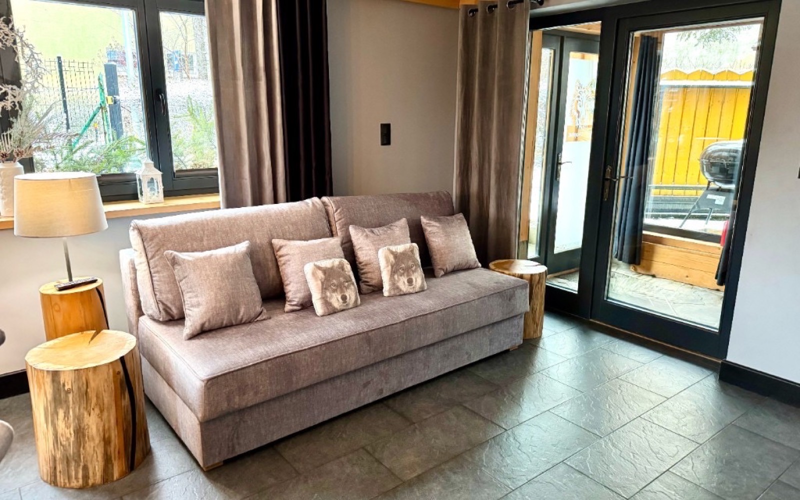Salon Wataha Home z sofą i oknami